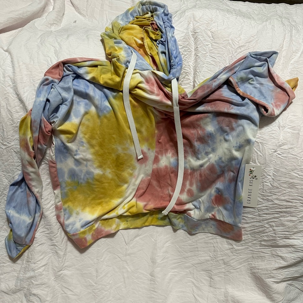 A hoodie. It’s tie dye with pink, yellow, blue, and white. It’s polyester.